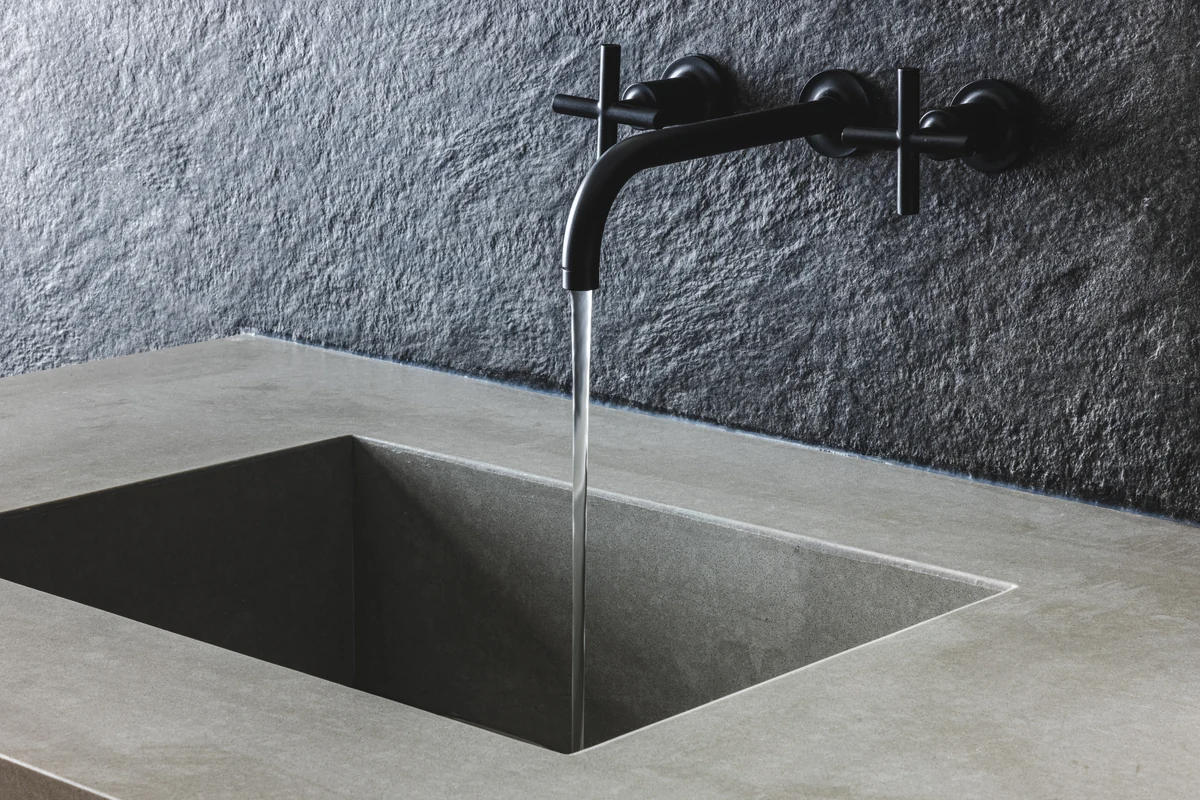 Basin, wall-mounted faucet, and textured bathroom wall at Skyward