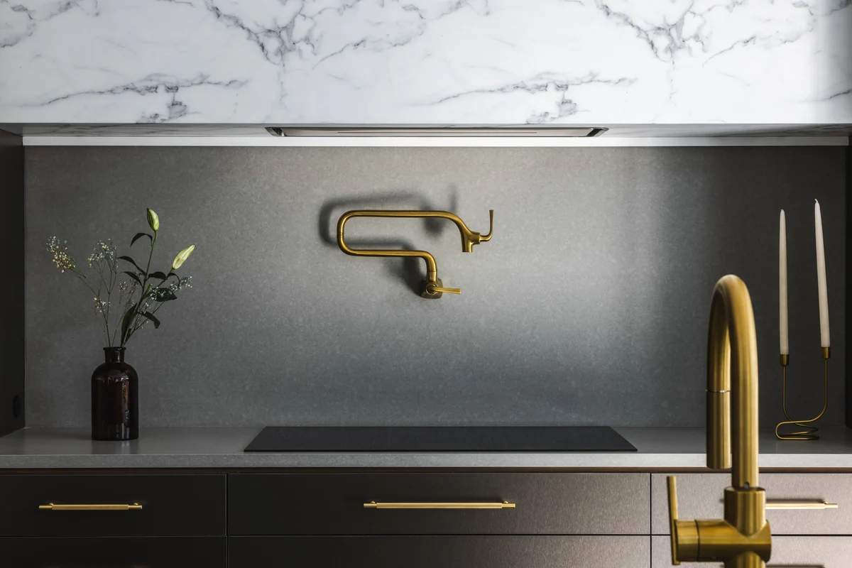 Kitchen backsplash, cabinetry, countertop, and wall-mounted fitting at Skyward