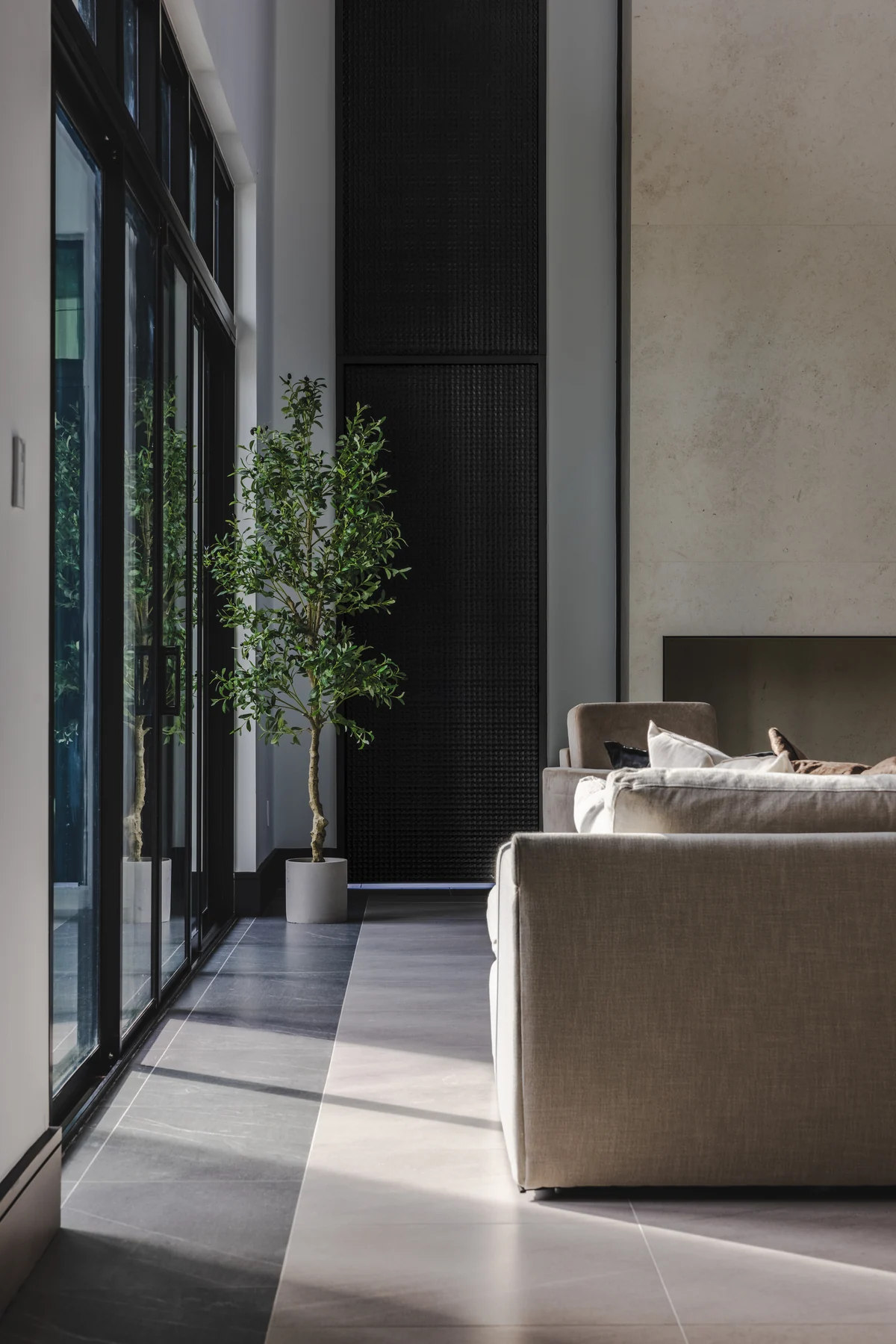 Living room seating beside tall garden-facing glazing at Skyward