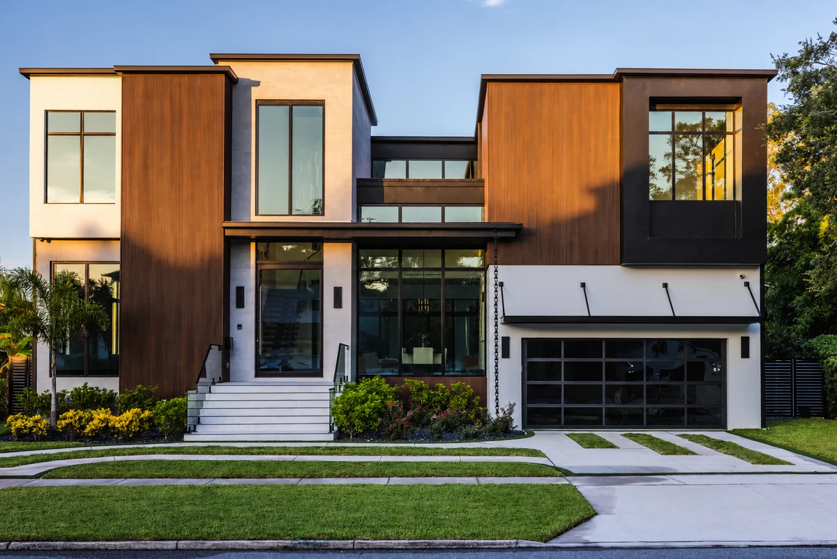 Front elevation of Skyward with warm vertical cladding, tall glazing, and landscaped entry